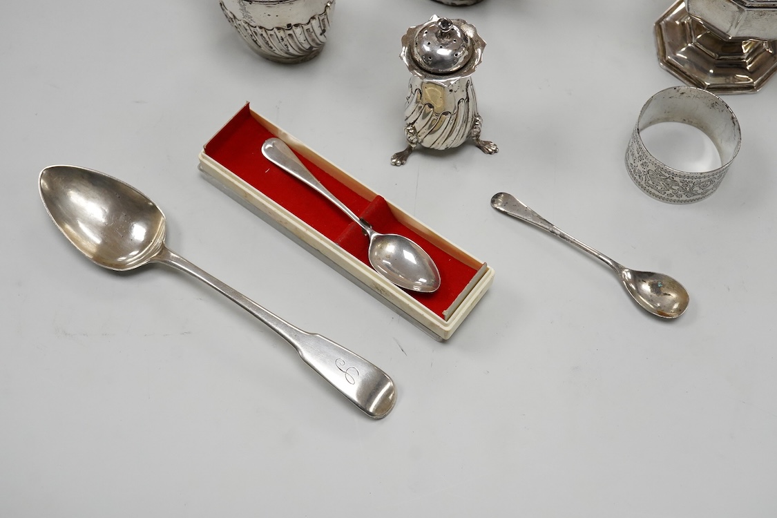 A George V silver octagonal sugar caster, Viners Ltd, Sheffield, 1932, 18.2cm, an Edwardian silver three piece condiment set by John Round, a silver napkin ring and three silver spoons including a dessert spoon by Peter,